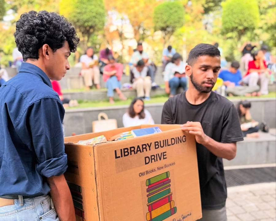 Volunteers carrying a Library Building Drive box