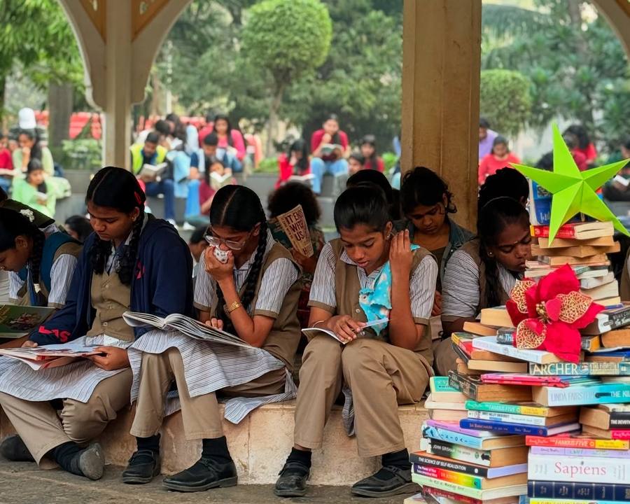 School children reading around piles of donated books