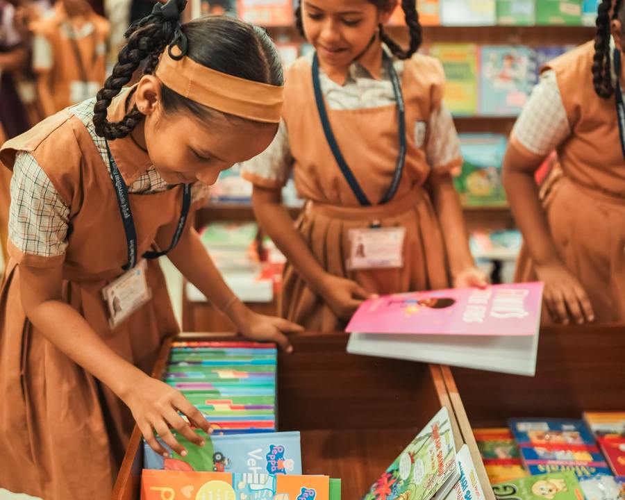 School girls picking books from a crate