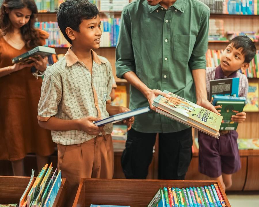 A volunteer handing books to a school boy