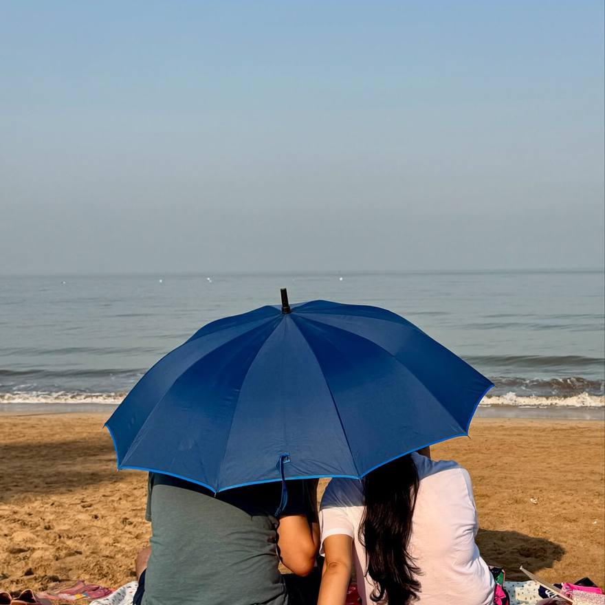 A reader under an umbrella on the beach