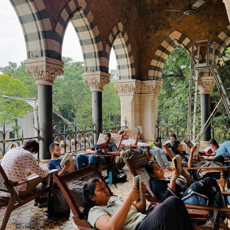 Readers along an arched colonnade