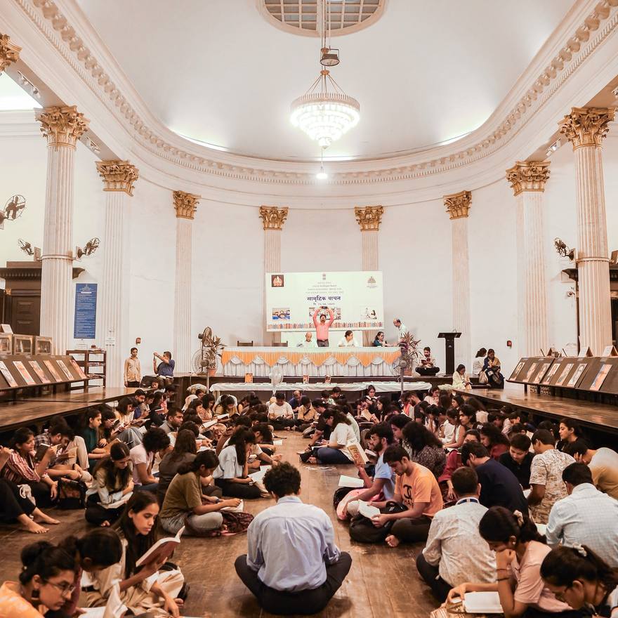 Readers seated on the floor of a domed hall