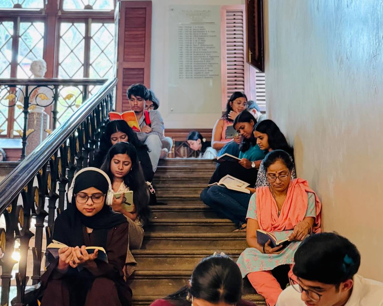 Readers on a staircase inside an arched heritage interior